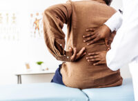 Patient indicating where their back pain is