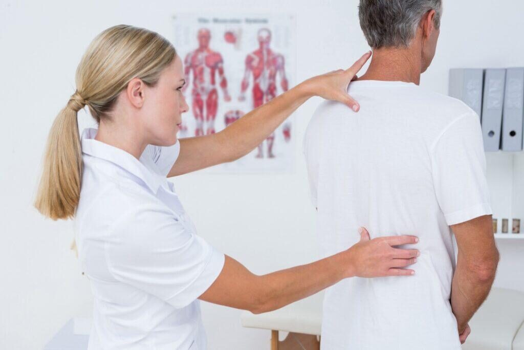 chiropractor touching patients back