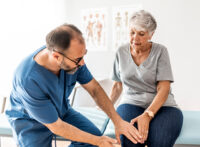 Physician holding a patient knee