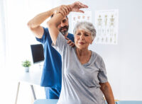 Physician stretching a patients arm