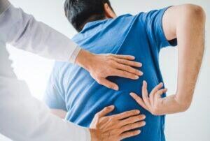 man showing where his back pain is