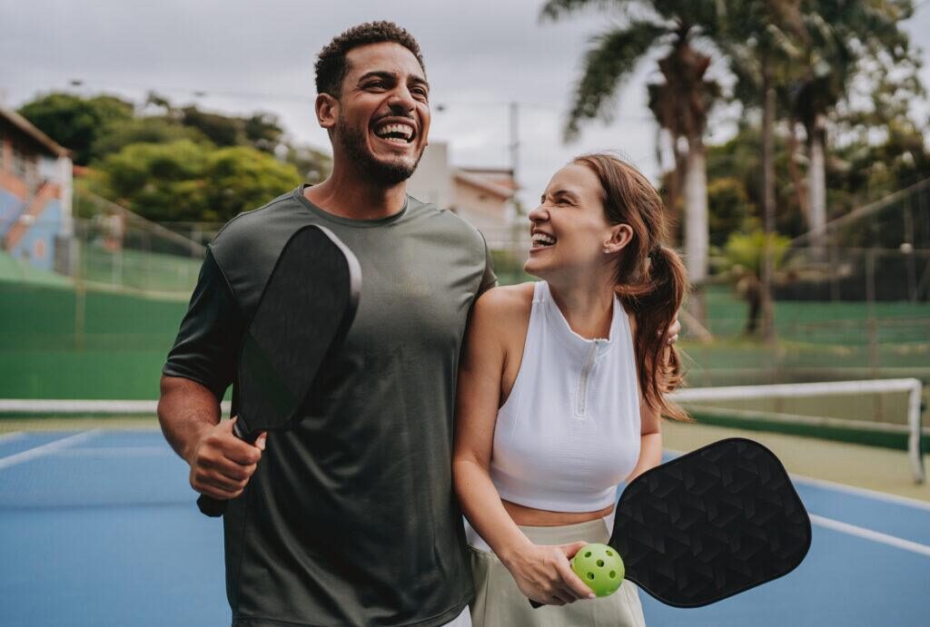 a couple holding pickleball rackets