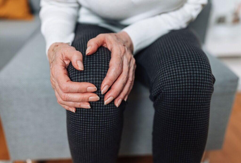 a woman holding her knee in pain