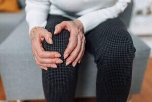 a woman holding her knee in pain