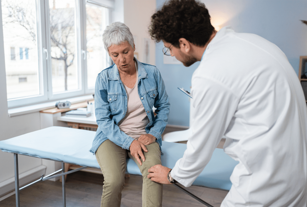 Doctor assessing woman's knee pain